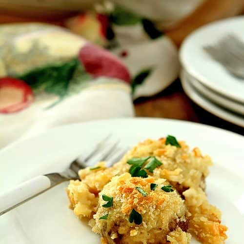 Serving of Baked Mushrooms on a White Plate. Mushrooms are baked in a Parmesan Cream Sauce.