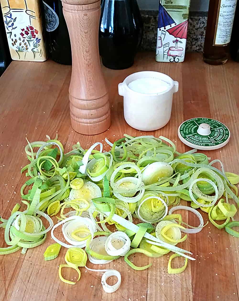 Fresh sliced leeks on a wooden surface for leek bacon potato cakes.