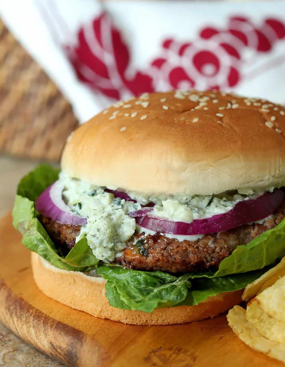 Vegetarian Greek veggie burger with bean patty, lettuce, onion, and Tzatziki Sauce.