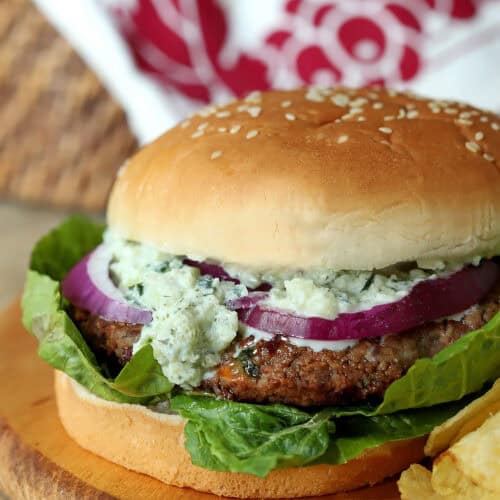 Vegetarian Greek veggie burger with bean patty, lettuce, onion, and Tzatziki Sauce.