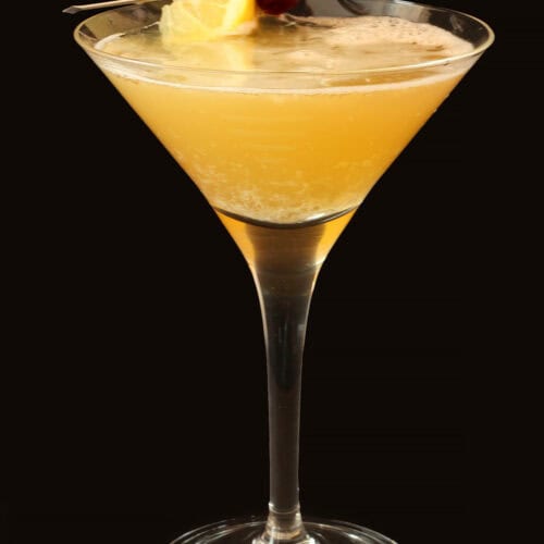 Classic whiskey sour cocktail with lemon and cherry garnish.